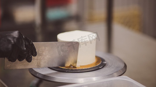 赶车鞭子摄影照片_厨师蛋糕用抹刀和餐具平滑磨砂蛋糕与奶油