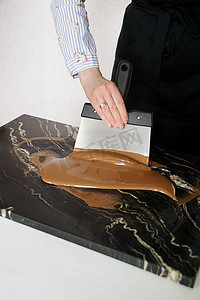 男巧克力师用抹刀搅拌调温后的液体巧克力