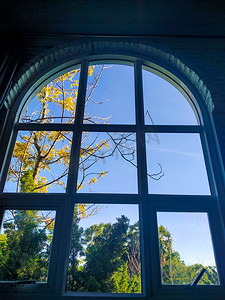 拱形窗户可欣赏秋天的风景，阳光明媚。