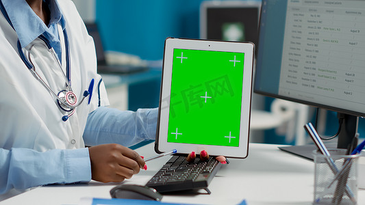 女医生在为瘫痪病人检查时手持带绿屏的平板电脑