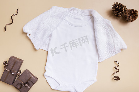 白色婴儿紧身衣模型，用于米色背景上的徽标、文字或设计，并具有冬季装饰顶视图