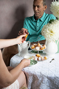 下午茶糕点摄影照片_英式茶歇，早上有鲜花和甜甜圈的静物