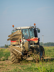 夏末农民驾驶拖拉机耕地