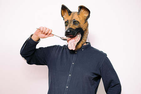 戴着狗面具的人用勺子吃饭
