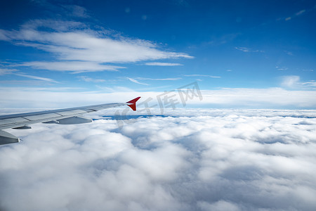 飞机机翼摄影照片_在美丽的云彩和蓝天之上的飞机机翼