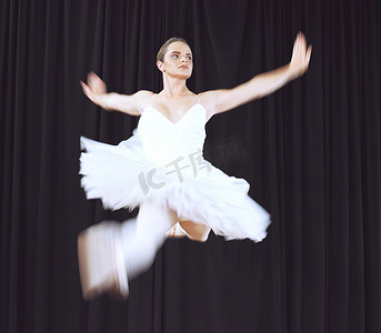 创意舞女摄影照片_芭蕾舞女舞者，在创意舞台表演期间跳舞在空中跳跃。