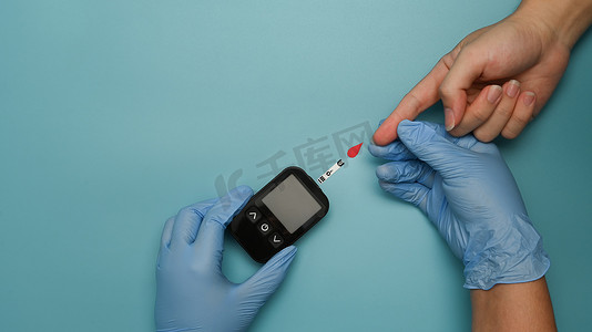 计量器摄影照片_医生使用血糖仪检查血糖水平。