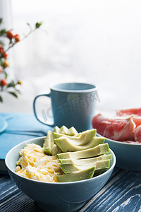 牛油果咖啡摄影照片_健康早餐：鸡蛋和鳄梨、葡萄柚和一杯咖啡。