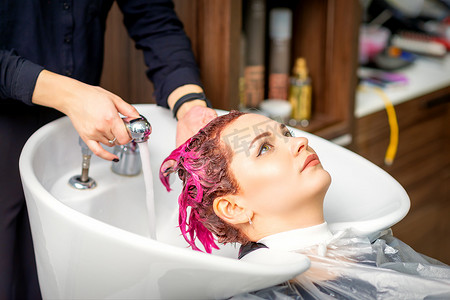 染头摄影照片_洗涤染过的女性头发。
