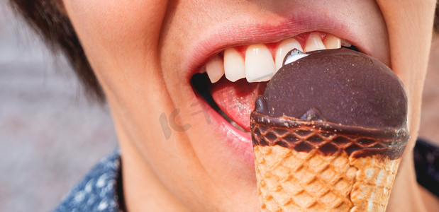 直播氛围图摄影照片_穿蓝色衬衫的男人正在吃冰淇淋。