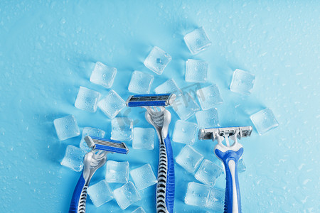 冷淡的蓝色背景上的三台剃须机加冰。