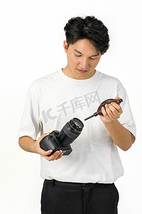 亚洲摄影师正在用吹风机清洁相机