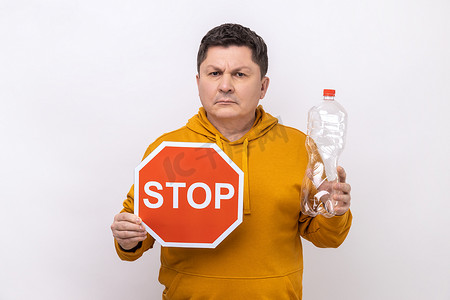 负责摄影照片_中年男子拿着塑料瓶和停止红色标志，担心环境。