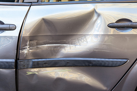 损坏的汽车，门上有划痕和凹痕，交通事故后汽车上有凹痕，