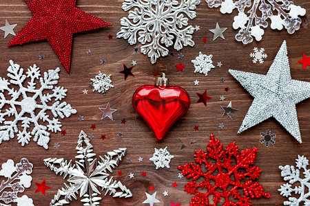 圣诞节和新年背景与圣诞装饰-球、星星、银色闪闪发光的雪花和木桌上的五彩纸屑。