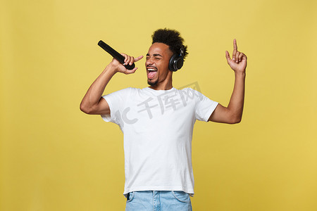 歌手演唱摄影照片_年轻英俊的非洲裔美国男孩用麦克风演唱歌剧情感。