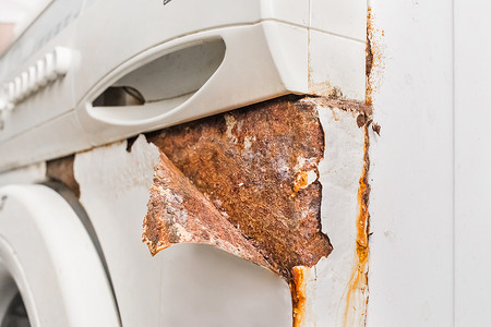 钙化摄影照片_旧坏洗衣机的生锈剥落角层。