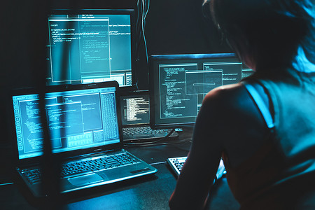 软件开发人员自由职业者女性晚上在宽显示屏上使用程序代码开发新的网络桌面移动应用程序。