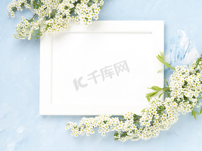 白色的花朵在蓝色混凝土背景的框架上。