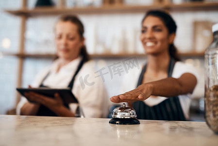 在咖啡厅、餐厅和咖啡店，女服务员手按着服务铃，准备好点餐。