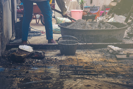水泥桶摄影照片_工人在大桶中搅拌水泥