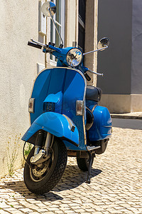 亮蓝色轻便摩托车停在欧洲街道上