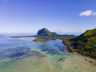 Le Morne 海滩毛里求斯，带棕榈树和白色沙滩蓝色海洋的热带海滩和带雨伞的沙滩床、太阳椅和遮阳伞在热带海滩的棕榈树下，Le Morne 海滩毛里求斯