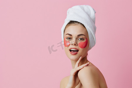 美丽的女人脸上有粉红色斑块，头上有一条毛巾，与世隔绝的背景