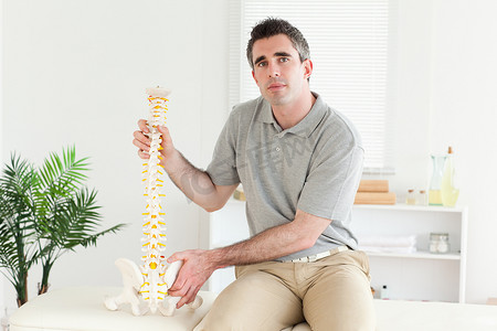 拿着脊柱模型的脊椎治疗师