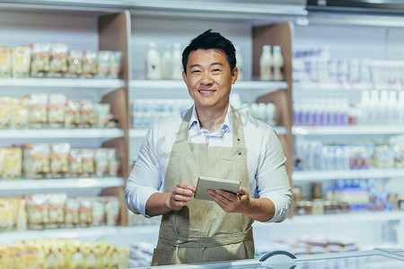 一位年轻英俊的亚洲男子、店主、超市工作人员的肖像