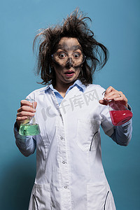 惊讶的疯狂化学专家拿着装满危险液体化合物的玻璃烧杯。