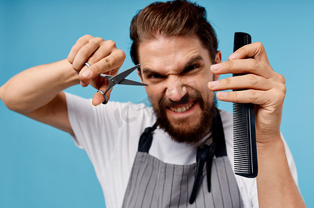 带剪刀和梳子模型胡须灰色围裙裁剪视图的情绪化男理发师