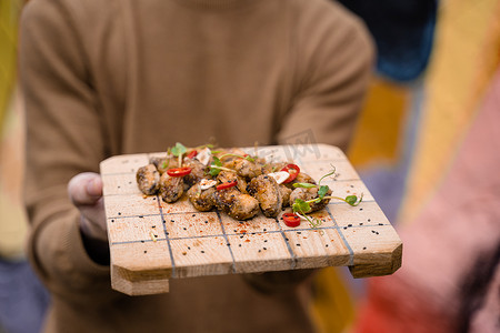 炸贻贝用辣椒、大蒜、芝麻、香草，在​​方形木板上。