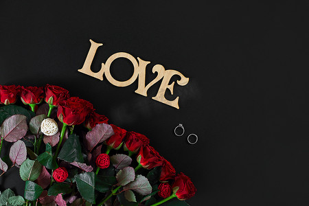 黑色背景上带木字 LOVE 的红玫瑰花
