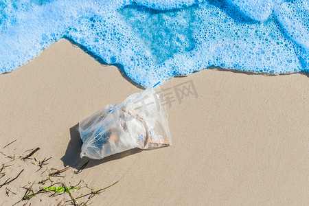 一小堆废物躺在靠近海边的海岸上，特写镜头。