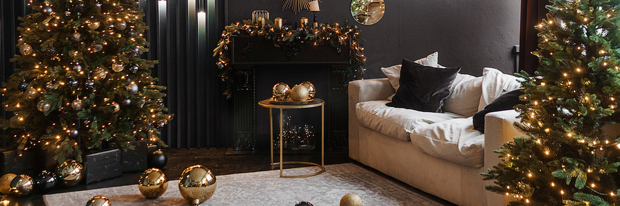 圣诞室内有一棵美丽的圣诞树、沙发、灯泡和深色背景。