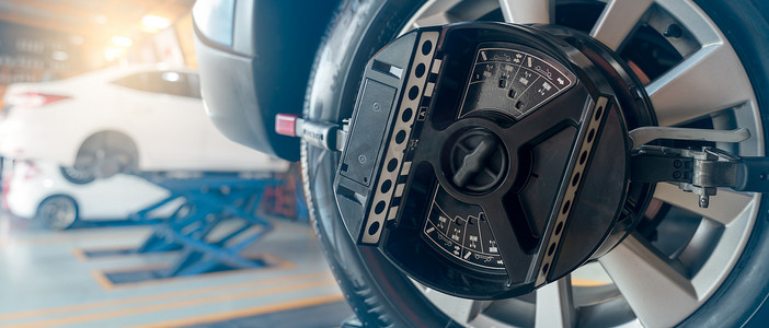 车轮定位设备在汽车修理店夹紧车轮轮胎。