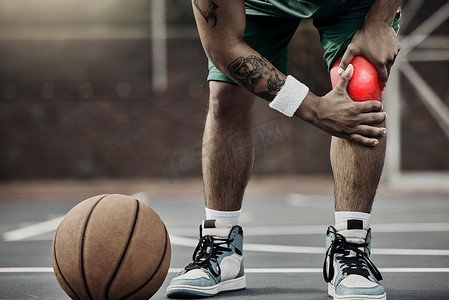 运动、篮球损伤和膝盖疼痛或运动员在户外球场上训练或出于爱好而锻炼时握住受伤的腿。
