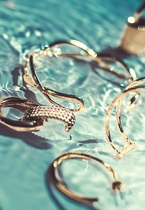 金手镯、耳环、戒指、翡翠水背景的珠宝、奢华魅力和珠宝品牌广告的假日美容设计