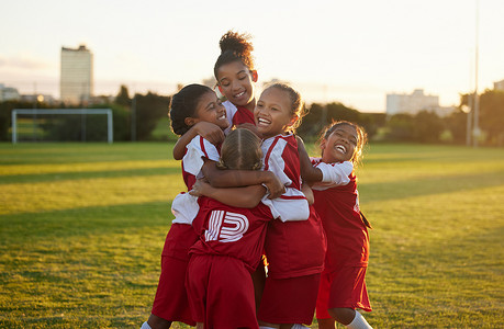 儿童足球队摄影照片_庆祝活动、获胜者和儿童足球队为在室外足球场上进球而高兴。