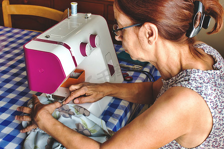 中年妇女用缝纫机做裙子
