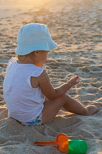 沙盘游戏摄影照片_巴拿马草帽的小女孩在海滩上玩耍