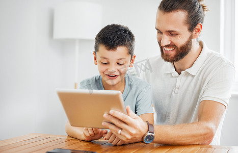 父子在家中通过平板电脑浏览在线学习材料，进行学习、教育和发展。