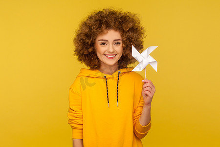 黄色背景上的情感卷发女孩的肖像。