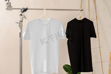 衣架上的白色和黑色 T 恤用于设计展示