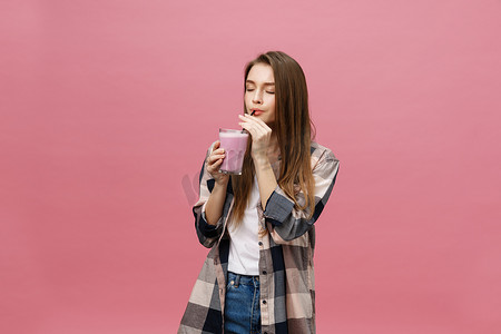 年轻女子用吸管喝果汁冰沙。