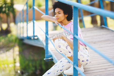 思念的摄影照片_坐在人行天桥上的梦幻黑人女人