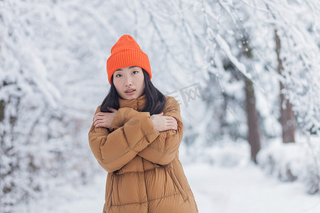 冬季女性摄影照片_冬季公园里孤独的亚洲女性，悲伤、沮丧、疲倦、冻僵，穿着暖和的衣服