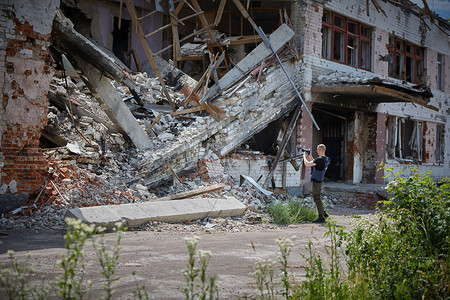 战地记者拍摄爆炸后被毁坏的建筑物