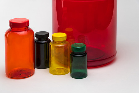 塑料罐透明摄影照片_白色背景上一些空的彩色塑料罐的特写镜头。